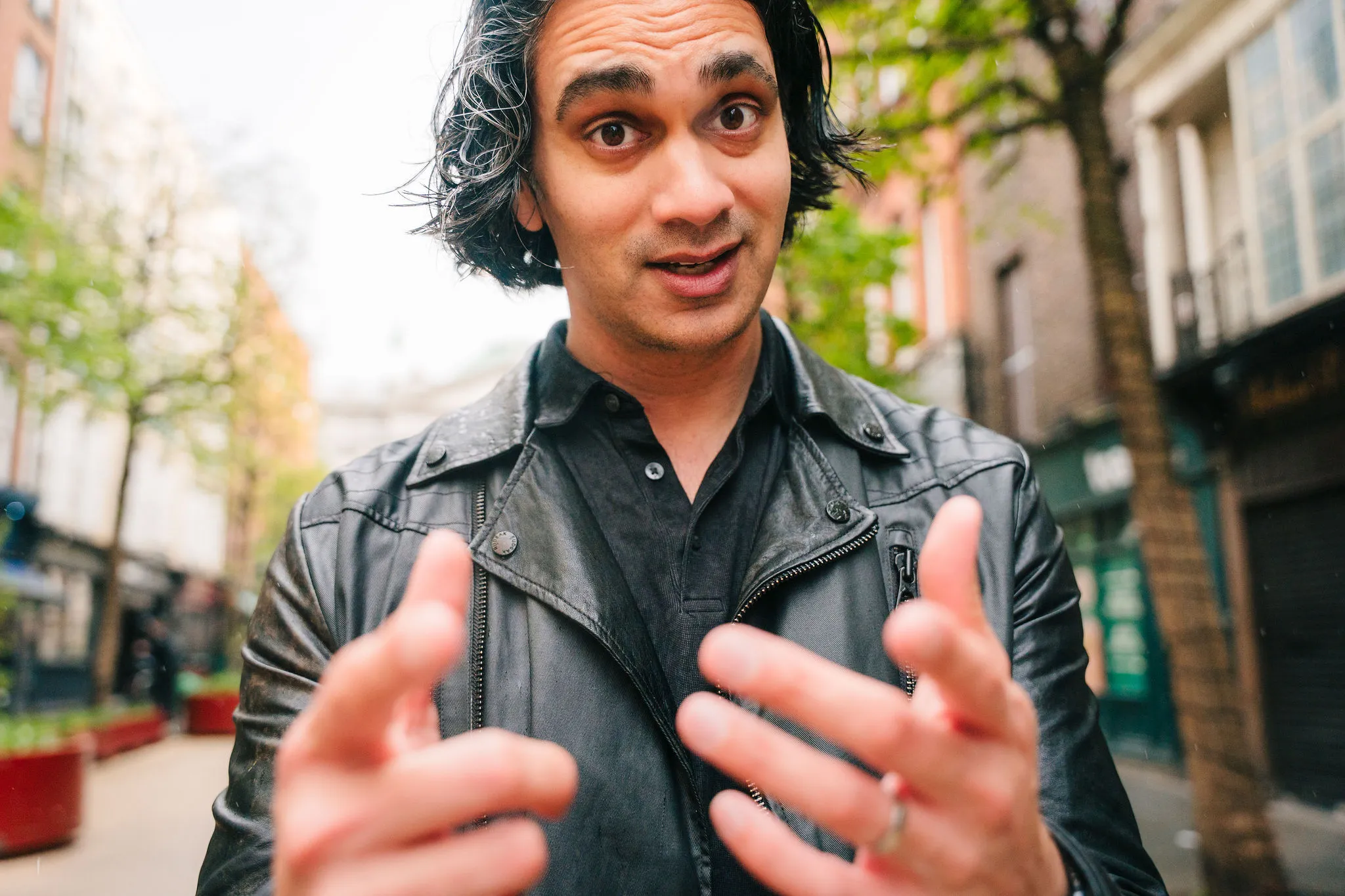 Aaron Rodericks speaking with animated hand gestures on a Dublin street